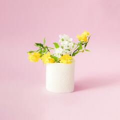 White cherry blossom with yellow flower and green leaf in toilet paper on a pink background.