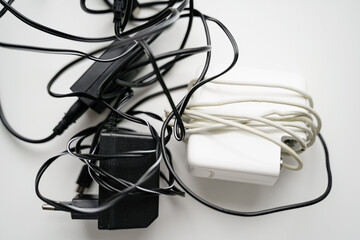 E waste, old cables and green plant. Gadget recycle of tech junk. Environment pollution