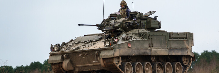 british army FV510 warrior light infantry fighting vehicle tank in action on a military battle...