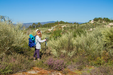 woman with backpack hiking in the bush
