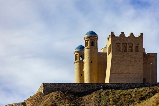 An ancient fortress on a hillside against the sky in the mountains.