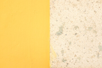 Beautiful wall background with half yellow and in the other half pretty color stone texture
