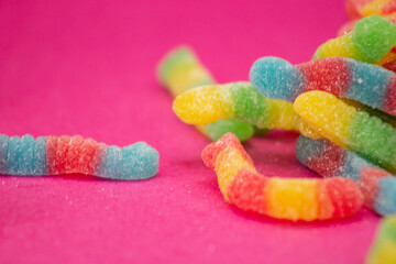 Gummy worms in close-up on pink background