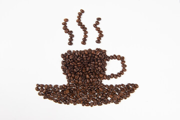 Roasted coffee beans placed in the shape of a cup and saucer on white background