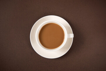 A cup of coffee isolated on brown background, top view