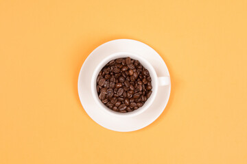 Coffee cup and coffee beans on yellow background