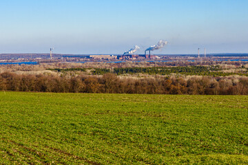 View on smoke pipes of the factory and agricultural field