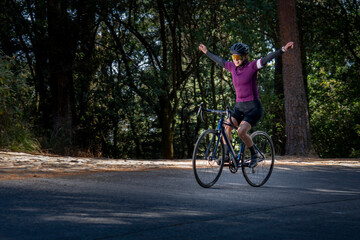 Mujer joven disfrutando de un paseo en bicicleta al aire libre en medio del bosque.