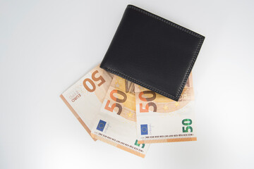Top view of a black leather wallet with 50 euro bills.