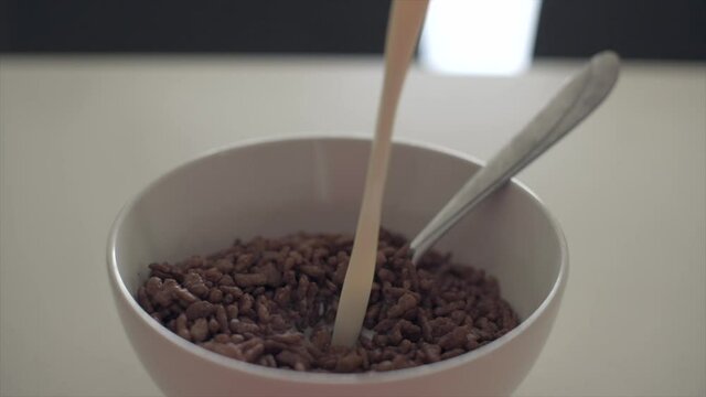 Pouring milk in chocolate cereal in slow motion