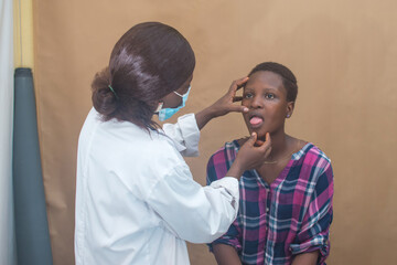 African female nurse , doctor or medical specialist checking a lady patient for health reasons, and also has stethoscope with her 