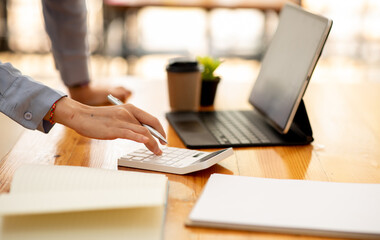 Close up of accountant working and analyzing financial reports project accounting with chart graph and calculator in modern office : finance and business concept.