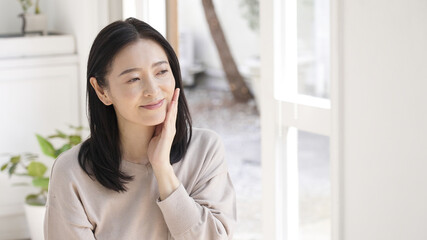 Fototapeta premium 美容・ビューティー 頬を触るミドル女性