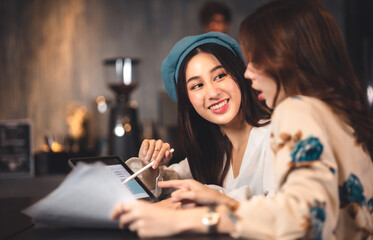 young asian woman Business people Working discuss finding new strategy solution.People discussion business plan using laptop at cafe.