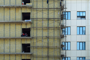 Insulation of apartment building at construction stage. Urban city life, development of standard houses