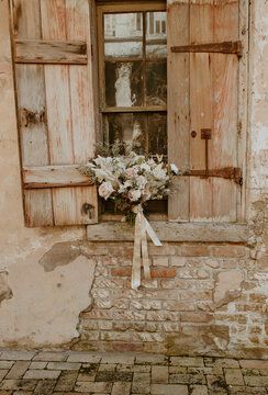bridal bouquet in window with brick wall