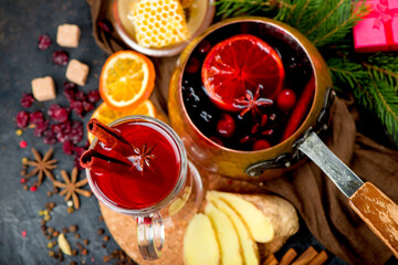 Mulled wine, blue pine tree branch and spices on wooden background