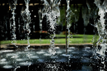 Abstract Water Falling From Various Shaped Nozzle's, In A Large Water Feature.