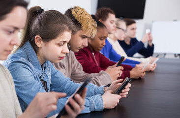 positive russian classmates using their smartphones heavily during classes