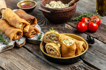 Savory crepe rolls, stuffed pancakes with ground meat filling. Traditional Russian Maslenitsa festival meal on wooden background