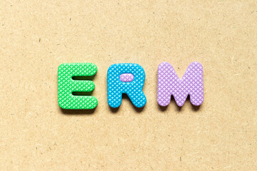 Fototapeta na wymiar Foam alphabet letter in word ERM (Abbreviation of Enterprise risk management) on wood background