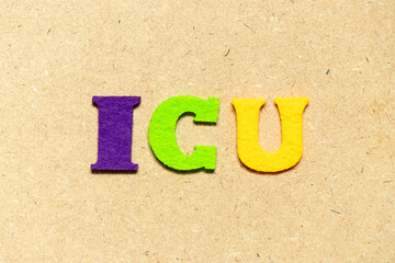 Color cloth alphabet letter in word ICU (abbreviation of intensive care unit) on wood background