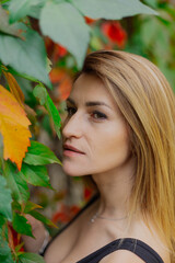Beautiful portrait of a young woman in autumn bushes.