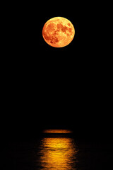 Super full blood moon and moon light over the sea