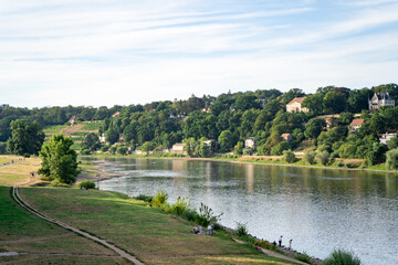 Obraz premium A beautiful view on the horizon of the green hills with villas, the calm river and a lawn with a path in the city of Dresden on a summer day. Travel and nature concept
