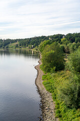 Fototapeta premium A beautiful view on the horizon of the green hills with villas, the calm river and a lawn with a path in the city of Dresden on a summer day. Travel and nature concept