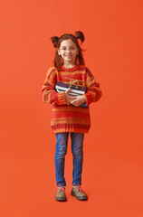 Cute little girl with books on color background