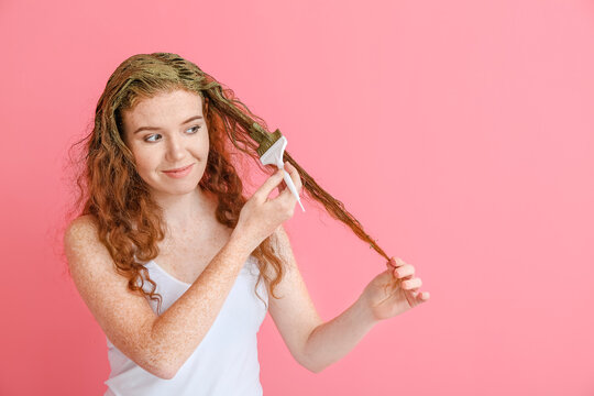 Young Woman Using Henna Hair Dye On Color Background