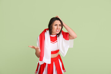 Upset cheerleader with the flag of England on color background