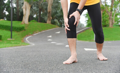 close up of young Asian sports man has pain at muscles and joints during outdoor exercise, over trainning or running and sport injuty concept