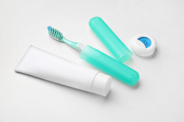 Tooth brush with case, paste and floss on white background