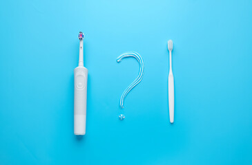 Different tooth brushes and question mark on color background