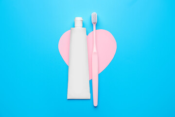 Tooth brush with paste and heart on color background