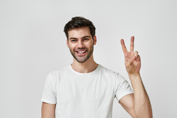 Fototapeta premium Bearded man wearing t-shirt showing peace gesture