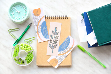 Notebook with bookmarks and stationery on light background