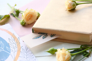 Book, bookmarks and flowers on light background, closeup