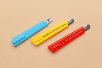 Stationery knives on color background