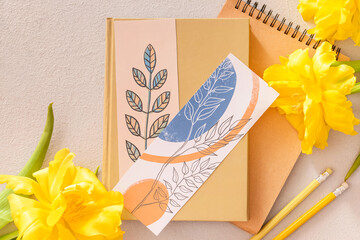 Notebooks with bookmarks and flowers on color background