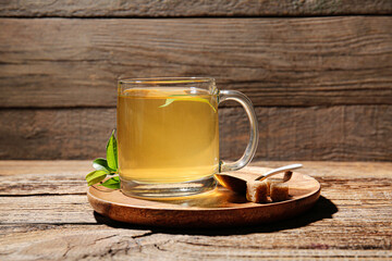 Glass cup of green tea on wooden background