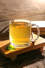 Tray with cup of green tea on wooden background