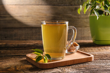 Tray with cup of green tea on wooden background