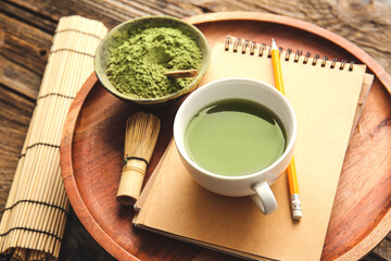 Composition with cup of matcha tea on wooden background