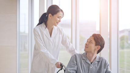 Obraz premium 車椅子に乗った患者を励ます医師