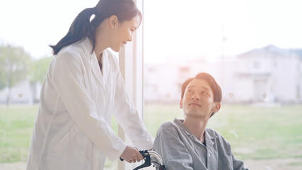 Obraz premium 車椅子に乗った患者を励ます医師