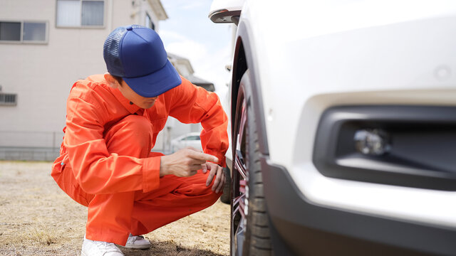 自動車のタイヤを点検する男性整備員