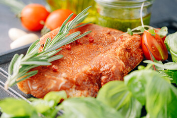 raw pork steak in spices and olive oil and basil dressing